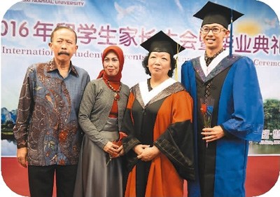 6月23日,參加廣西師范大學(xué)畢業(yè)典禮的留學(xué)生及家長與廣西師范大學(xué)黨委書記王枬(右二)合影。中新社記者