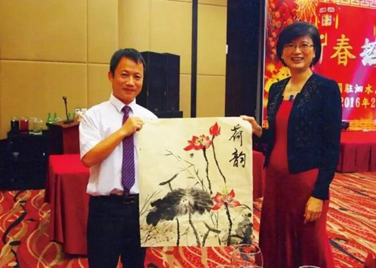 2016年在印尼泗水總領(lǐng)事迎春春節(jié)招待會上,張立(左)作畫贈給總領(lǐng)事于紅。