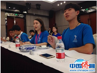 圖為西班牙華裔男孩張約翰認(rèn)真聽(tīng)如何握筆