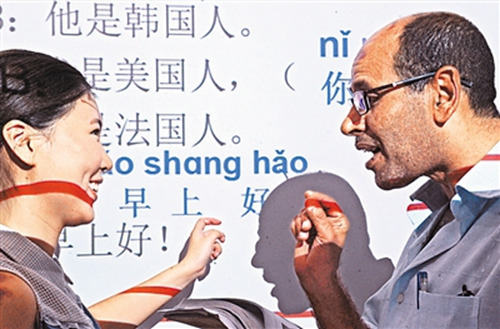 埃及客商埃勒賽義德(右)向老師學(xué)說(shuō)“早上好”。(新華社記者