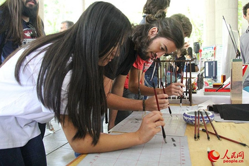 里約孔院中國日活動(dòng)現(xiàn)場(chǎng),孔院教師進(jìn)行中國書法現(xiàn)場(chǎng)教學(xué)。