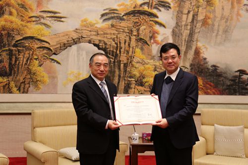 中國僑網(wǎng)賈益民向薛曉峰頒授華僑大學(xué)第七屆董事會副董事長聘書