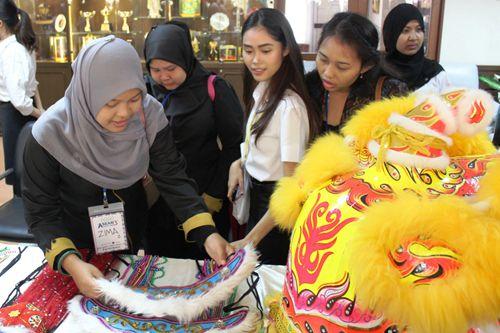 中國僑網(wǎng)文化展臺(tái)前多國師生欣賞精湛的工藝飾品