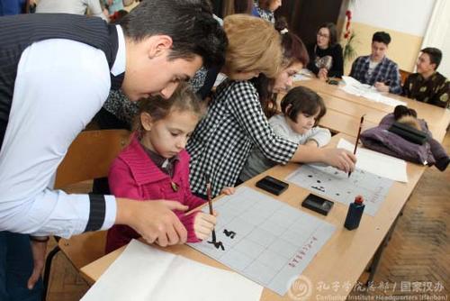 中國僑網(wǎng)學(xué)生解說員教小朋友寫書法