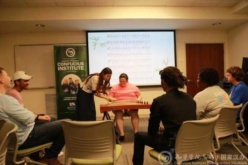 中國(guó)僑網(wǎng)志愿者教師王超指導(dǎo)學(xué)生彈奏古箏