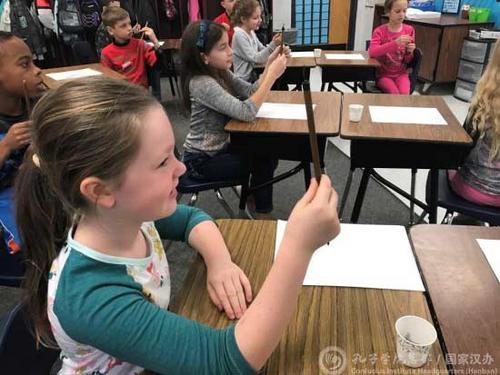 中國僑網(wǎng)美國小學(xué)生學(xué)習(xí)怎么拿毛筆