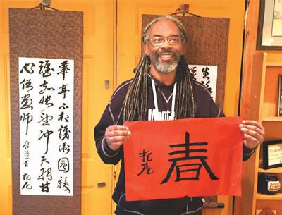 中國僑網(wǎng)圖為托尼在展示自己的書法作品。 (屠新時)