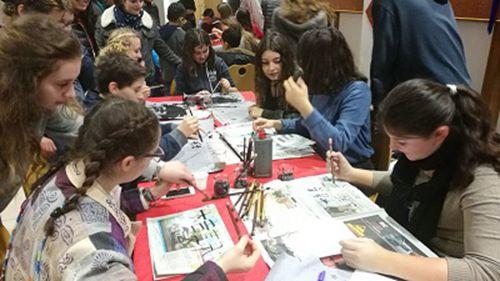 中國僑網(wǎng)資料圖:學(xué)習(xí)中文的學(xué)生展示中國傳統(tǒng)書法 (來源:外交部網(wǎng)站)