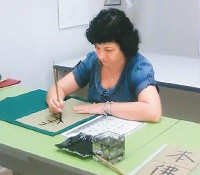 中國僑網(wǎng)蘇珊娜在臨摹“弘一體”漢字