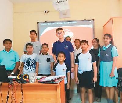 中國僑網(wǎng)許安(中)和學生們在一起。(圖片來源:《人民日報海外版》)