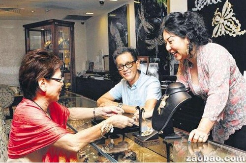 “發(fā)”珠寶行董事關(guān)添發(fā)(中)與太太鄭寶玩(右)與顧客陳如琳成為朋友。(新加坡《聯(lián)合早報(bào)》)