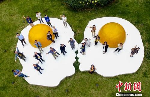 中國(guó)僑網(wǎng)航拍海外華文媒體代表參觀武漢東湖綠道在藝術(shù)景觀前合影 鄭子顏 攝