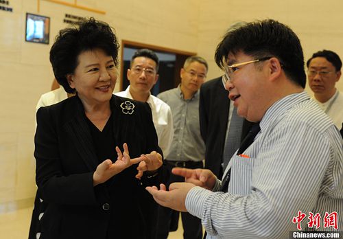 中國國務院僑辦主任裘援平與微總部科技發(fā)展有限公司董事長徐德清交流。中新社記者