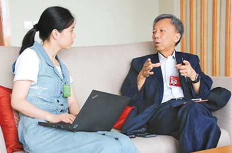 圖為方君學(xué)(右)接受記者采訪。