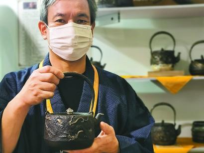 中國僑網(wǎng)進(jìn)博會(huì)參展商荒井干雄展示他最喜歡的生鐵雨龍壺。 本報(bào)記者 李曄 欒吟之 攝