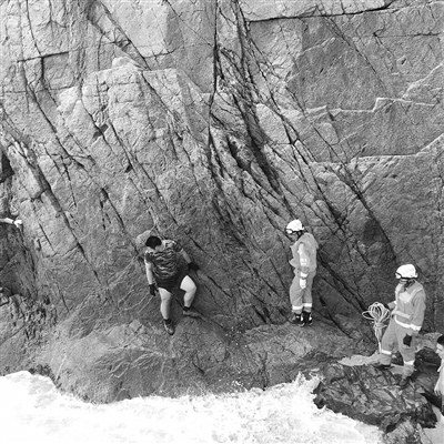 前往事發(fā)地點(diǎn)的路多為礁石崖壁,救援人員小心翼翼地前行