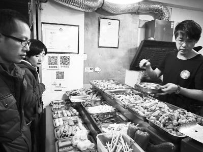 中國僑網(wǎng)柯武義(右)在店里忙著給顧客打包。