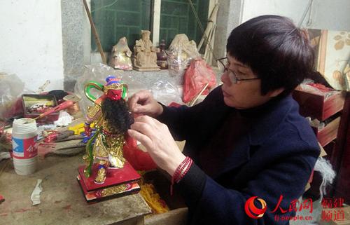 中國(guó)僑網(wǎng)洪碧虹正在為即將完工的佛像栽胡須。