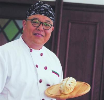 中國(guó)僑網(wǎng)鄧宇鈞在展示做好的面包。(資料圖片)