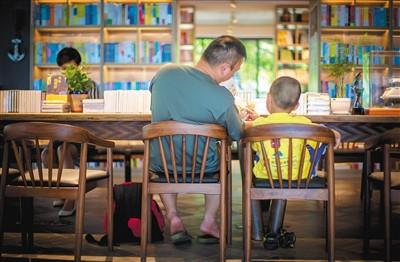 中國僑網(wǎng)圖為父親給孩子念繪本。海南日報記者 宋國強 攝