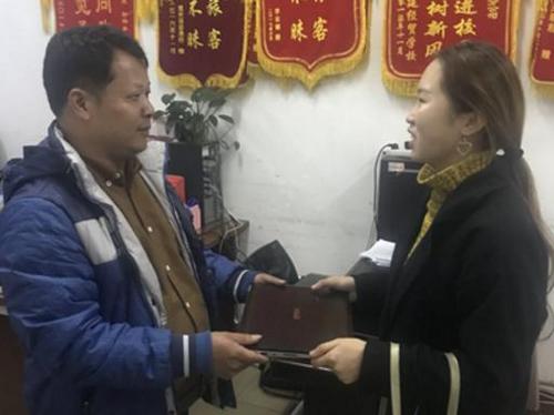 中國(guó)僑網(wǎng)駕駛員梁師傅將失物交給失主小余