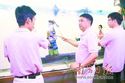 中國僑網(wǎng)蔡勁筍(中)對傳承潮俗皮影非常執(zhí)著。受訪者供圖