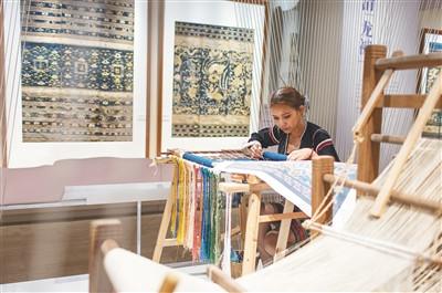 中國僑網(wǎng)黎族織錦藝人展示龍被織繡場景。 本報(bào)記者 宋國強(qiáng) 攝