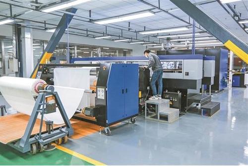 中國僑網(wǎng)溢達公司工人在使用智能化設備工作