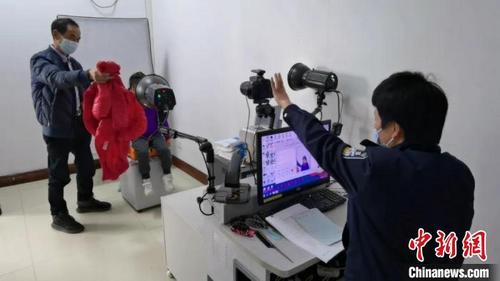 中國僑網(wǎng)浙江溫州甌海民警為小華僑拍攝證件照 鐘盈盈 攝