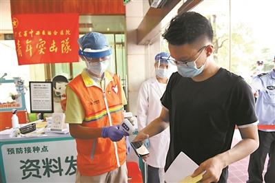 中國僑網(wǎng)胡偉雄(左)在廣東省中西醫(yī)結(jié)合醫(yī)院進行志愿服務。(全媒體記者 陳楓)