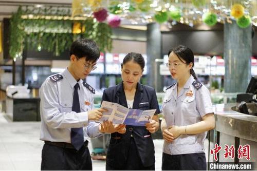 中國僑網(wǎng)圖為佛山稅務人員向餐飲企業(yè)介紹社保費緩繳政策 張健聰 攝