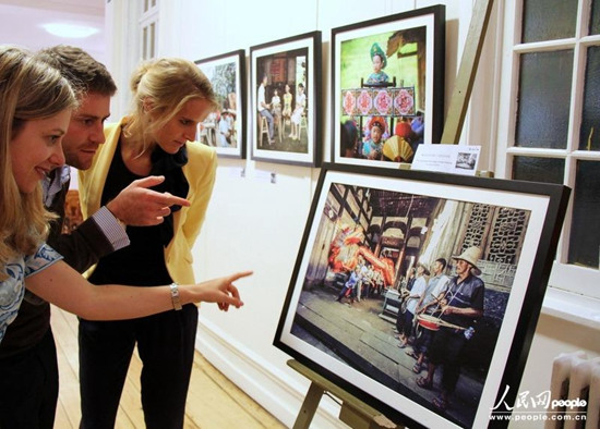 幾名布魯塞爾的觀眾正饒有興趣地欣賞一幅展出的照片。人民網(wǎng)記者