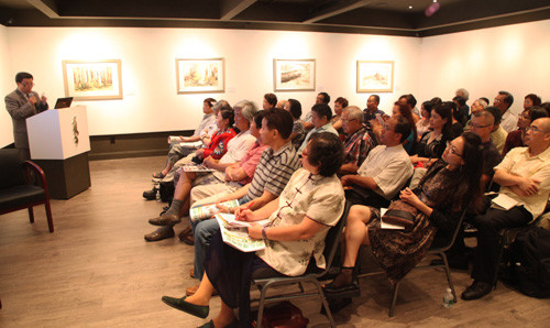 徐白一教授在展覽開幕前于黃氏藝?yán)戎髦v中國畫。(美國《僑報(bào)》/陳儒斌