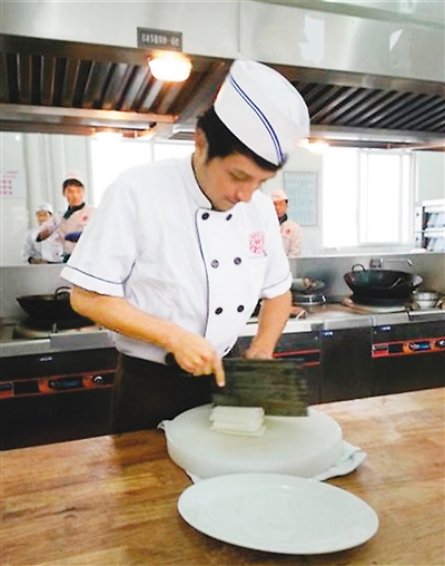 秘魯小伙兒阿爾弗雷多正在學做川菜。