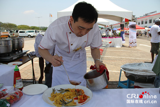 中國僑網(wǎng)中國大使館大廚正在往“二龍戲珠”上澆汁。(劉暢 攝)