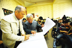 中國僑網(wǎng)來自新加坡的鄭朝吉(左)和八十歲的李崇望(右)投入緊張排練。(姚文生 攝)