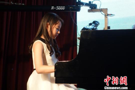 中國僑網(wǎng)圖為華裔少女王逸心在演奏。莫成雄 攝