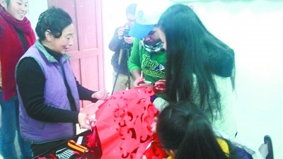 中國僑網(wǎng)何教授(左二)在教留學(xué)生剪紙。(李芳 攝)