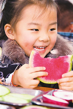 中國僑網(wǎng)山東棗莊實驗幼兒園的小朋友在吃生蘿卜“咬春”。(新華社發(fā))