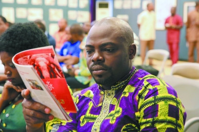 中國僑網(wǎng)貝寧媒體記者認(rèn)真閱讀“歡樂春節(jié)”宣傳冊(cè)。(曹肅 攝)