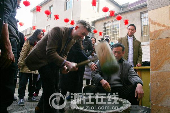 中國(guó)僑網(wǎng)老外體驗(yàn)打年糕。