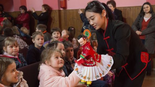 中國(guó)僑網(wǎng)演員向觀眾展示木偶。