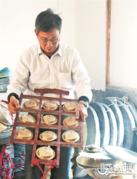 中國(guó)僑網(wǎng)十音銅鑼的第十一代傳承人黃火輪對(duì)制作完成的銅鑼進(jìn)行試音。
