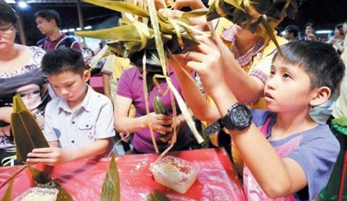 中國僑網(wǎng)小朋友在大朋友指導(dǎo)下, 小心翼翼?Ⅳ兆永?好。(馬來西亞《詩華日報》)