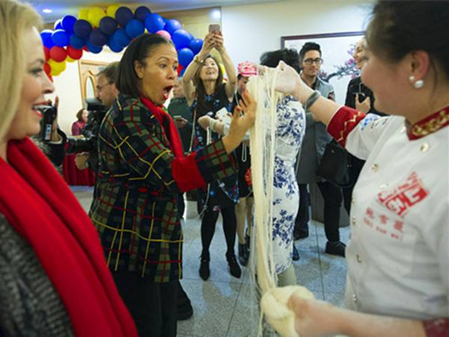 圖為洛杉磯市前禮賓局局長埃爾加·夏普(前左二)對鮑雪薇師傅制作的超細(xì)龍須拉面驚嘆不已。(楊磊