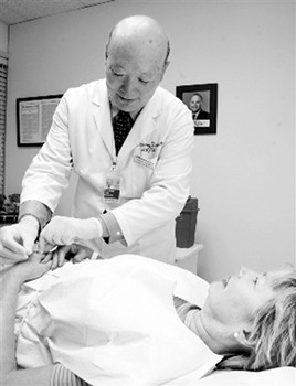 圖為華人中醫(yī)師田小明在為病人診治