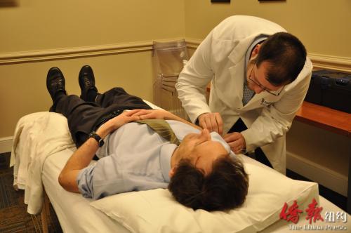 白居安給患者進(jìn)行針灸(美國《僑報(bào)》)