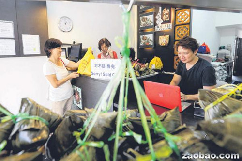 和記肉粽去年底設立網(wǎng)站讓顧客上網(wǎng)預訂粽子,少東周崇青(右)希望通過這項服務吸引年輕顧客群(新加坡《聯(lián)合早報》/謝智揚