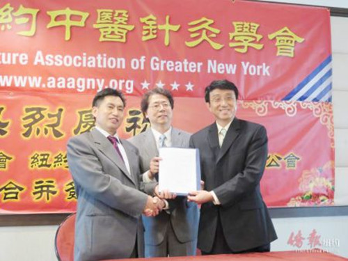 樂貴祥(左)與陳大志(右)簽署合并協(xié)議。(美國《僑報》/王伊琳