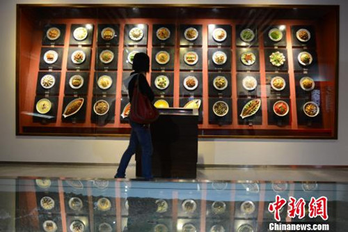 資料圖:數(shù)十種固定于墻上的“川菜”讓游客垂涎。(張浪